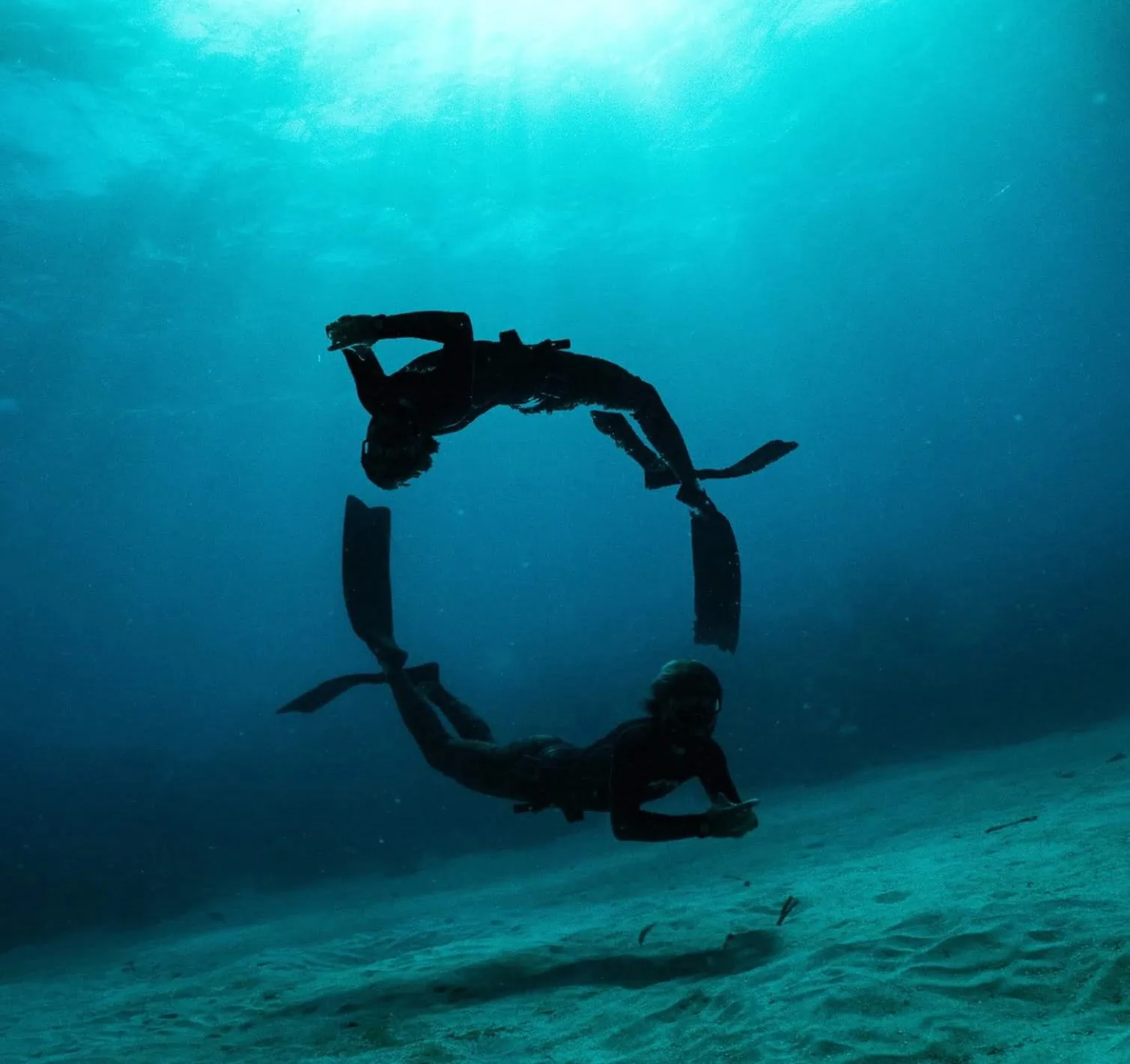 A freediver in turquoise water above the reef